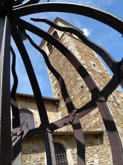 L'église médiévale de la Chartreuse de sainte croix en Jarez vue à travers la grille d'entrée (ferronerie d'art)