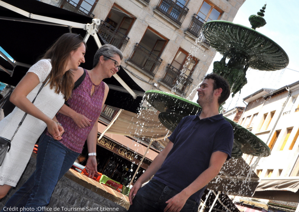 Un groupe en visite s'amuse devant une fontaine à Saint-Etienne